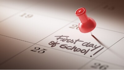 photo of a calendar with a push pin on the date labeled 'first day of school'