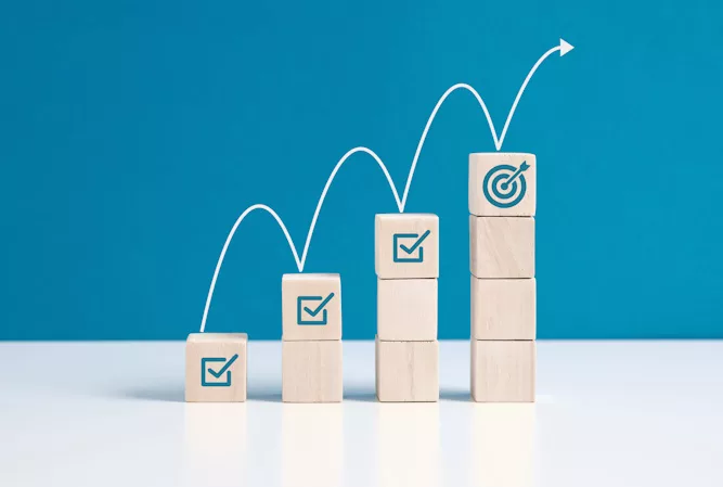 Four stacks of wood blocks with checkmarks and a target connected by a bounding arrow.