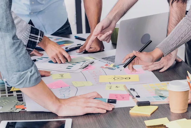 people standing around a table and planning